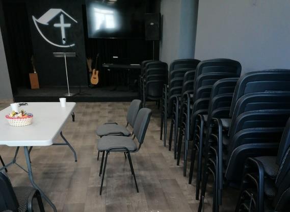 Kerkzaal met opgestapelde stoelen